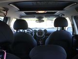 the interior of a small car with black seats and a pink handlebar