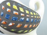 a black and white vase with a colorful design on it