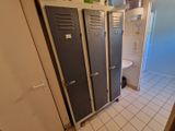deux casiers dans une salle de bains équipée de toilettes et d'un lavabo
