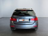 the back end of a silver bmw car in a white room