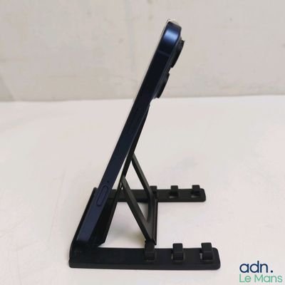 une tablette noire posée sur un support, sur une surface blanche