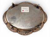 an antique silver plate on a stand on a white surface