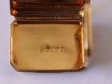 a gold watch sitting on top of a white table