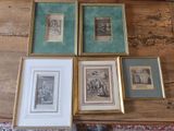 four framed pictures on a table with a cat sitting on it