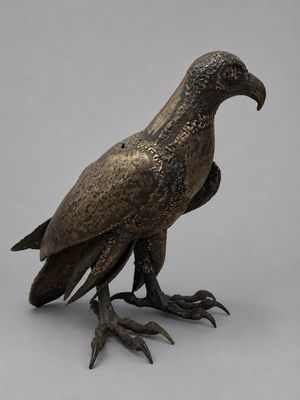 une image représentant une statue en bronze d'un oiseau sur fond gris