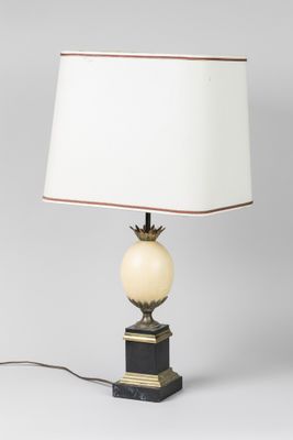 une lampe de table surmontée d'un abat-jour blanc