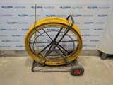 a yellow hose sitting on a cart in front of a wall