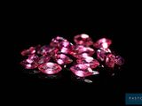 a pile of pink diamonds on a black surface