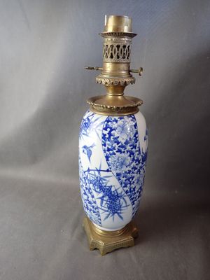 un vase bleu et blanc posé sur un socle doré