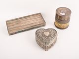 deux boîtes en argent et une boîte en bois posées sur une surface blanche