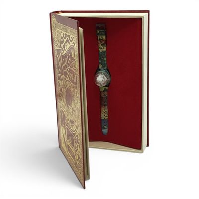 a book with a watch inside of it on a white surface