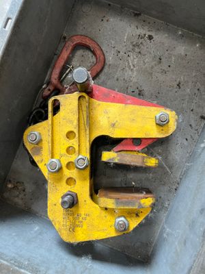 a yellow pipe clamp sitting in a metal box