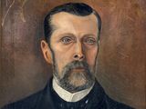 portrait d'un homme barbu vêtu d'un costume noir et d'un nœud papillon