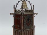 a small clock with a bell on top of it