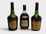 three bottles of liquor are lined up on a white surface
