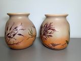 two vases that are sitting on a table