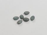 a close up of a group of green stones on a white surface