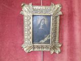 a picture of a woman in a gold frame on a red wall