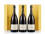three bottles of champagne in front of a yellow box