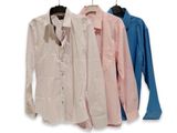 three shirts hanging on a clothes rack on a white background