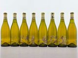 six bouteilles de vin blanc alignées sur une table