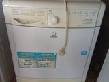 une photo d'une machine à laver dans un coin d'une pièce