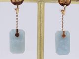 a close up of a pair of earrings on a stand