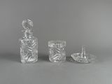 trois verres posés sur une table, avec une bougie et une bouteille