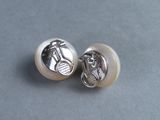 pair of white pearl earrings with a motorcycle motif on them