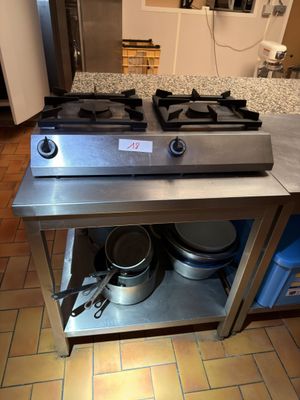 un plan de travail en acier inoxydable sur lequel sont posés des casseroles et des poêles