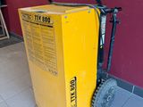 une boîte jaune posée par terre à côté d'un chariot noir