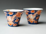 two blue and orange cups with dragon designs on them