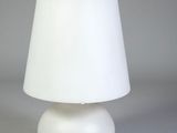 a white table lamp with a white shade on it