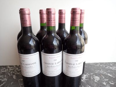 four bottles of red wine are lined up on a table