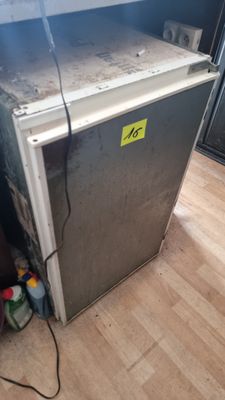 un réfrigérateur qui se trouve dans le coin d'une pièce