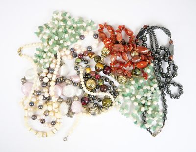 beaucoup de perles et de colliers sur un fond blanc