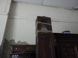 une horloge posée sur un meuble, dans un coin de la pièce