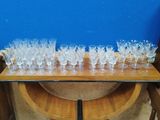 de nombreux verres posés sur une table, avec un mur bleu en arrière-plan
