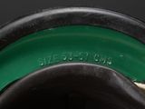 a close up of a green vase with a black rim