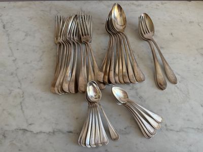 cinq cuillères en argent et six cuillères en argent posées sur une table en marbre