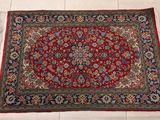 un tapis posé au sol, sur fond rouge