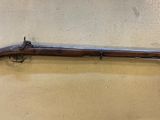 un vieux fusil fixé au mur d'une pièce