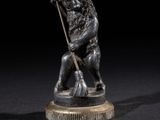 figurine en bronze représentant un homme tenant une lance, sur fond noir