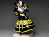 a black and yellow figurine of a woman holding a baby
