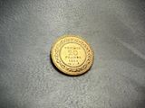 a close up of a gold coin on a gray surface