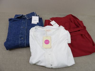 trois paires de vêtements pour bébé posées les unes à côté des autres sur un canapé