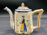 an image of a teapot with a woman in a blue dress
