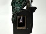 statue d'un homme assis sur un socle, tenant un miroir à la main
