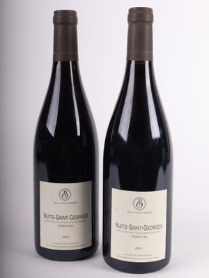 two bottles of wine sitting next to each other on a white surface