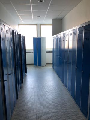 de nombreux casiers bleus dans le couloir d'un immeuble